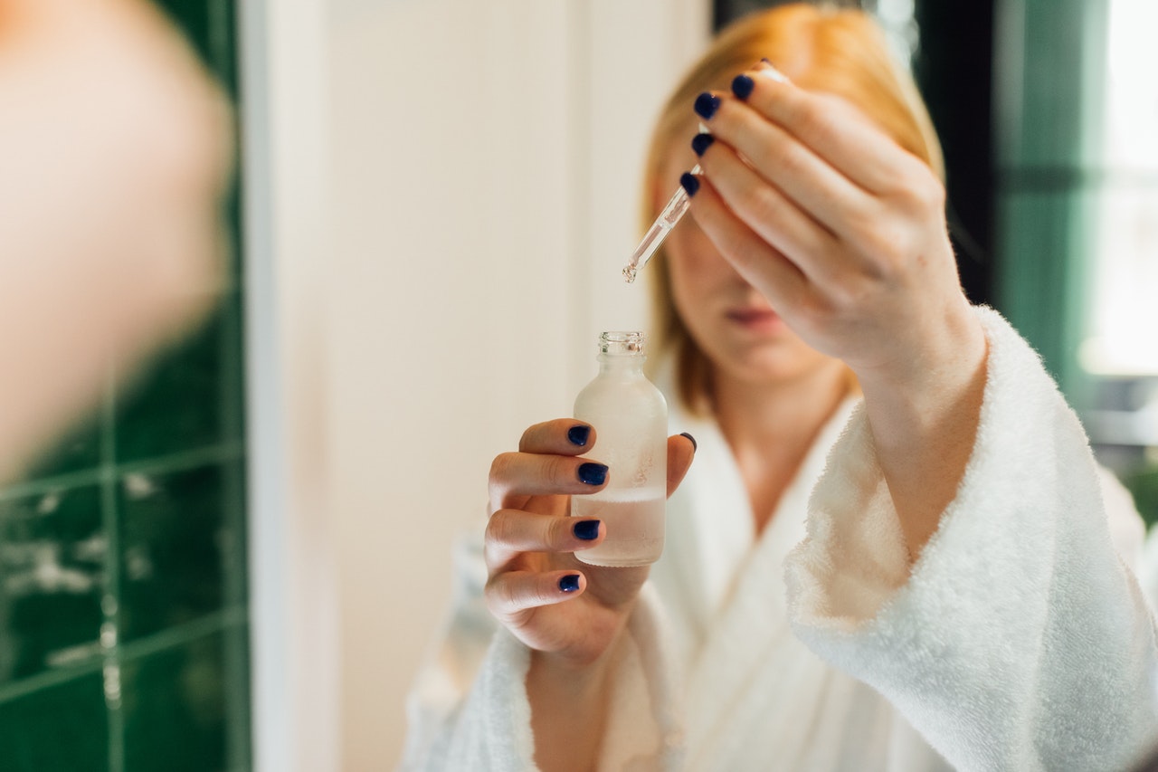 Kvinna använder serum i ansiktet