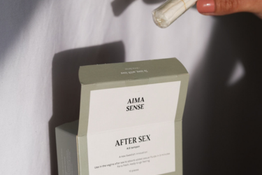 En bild på en hand som plockar ut en tampong ut ur förpackningen Aima Sense After sex tampong.