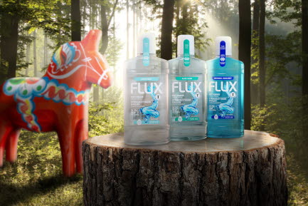 En grupp Flux munsköljprodukter (Mild Mint, Aloe Vera och Original Coolmint) stående på en trästubbe i en skogsmiljö med en svensk dalahäst i bakgrunden. Produkten är förpackad i 100% återvunnen plast.